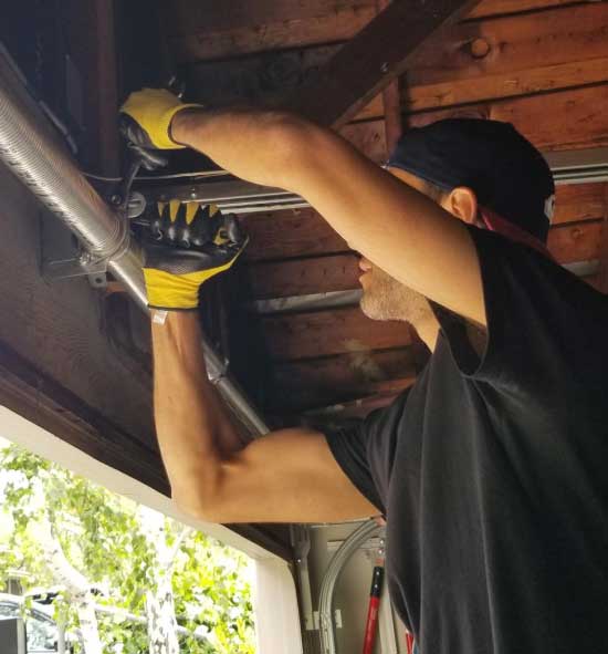 man repairing top of garage